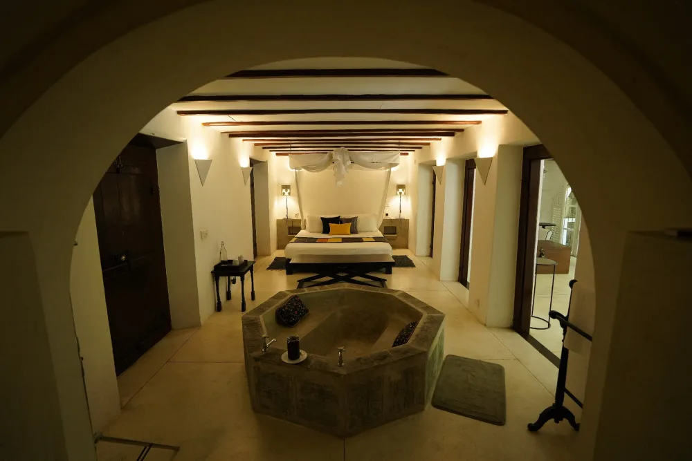 Elegant black raja bedroom at Adigar's manor, showcasing a bed alongside a modern bathtub.