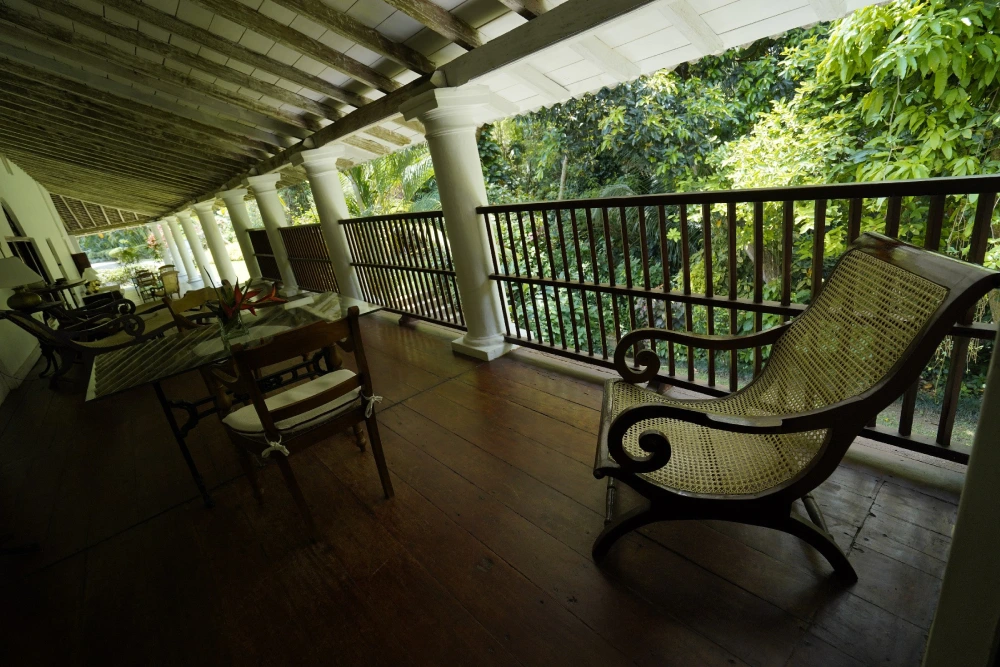 Classic furniture rests on a rich wooden floor in Adigar's manor, highlighting the timeless elegance of the space.