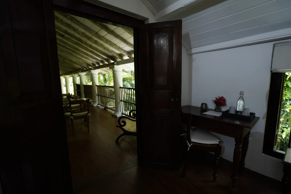The Admiral bedroom at Adigar's Manor, displaying a table and chairs in a refined and inviting atmosphere.