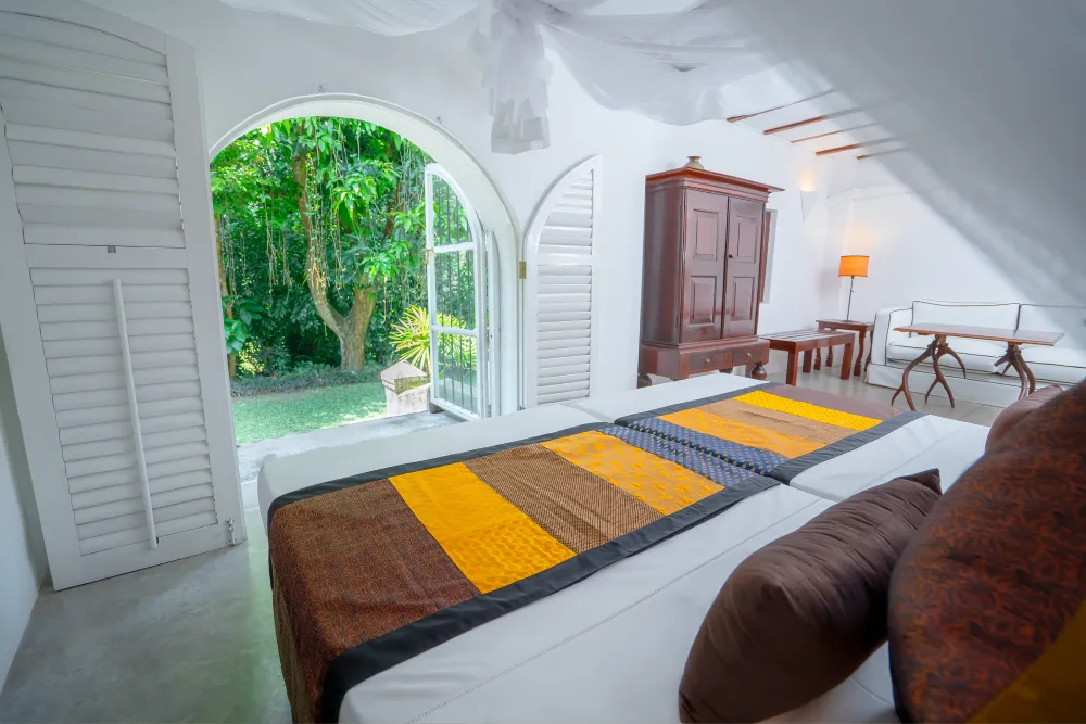 Monkey Puzzle Room with elegant canopy bed, soft ambient lighting, colonial-style interiors, and private balcony access