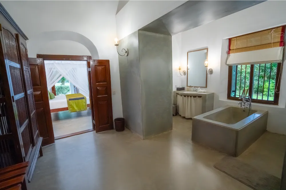 Redspot Duke Room bathroom with spacious open-plan design, elegant stone bathtub, minimalist vanity, and serene colonial-style interiors overlooking lush greenery